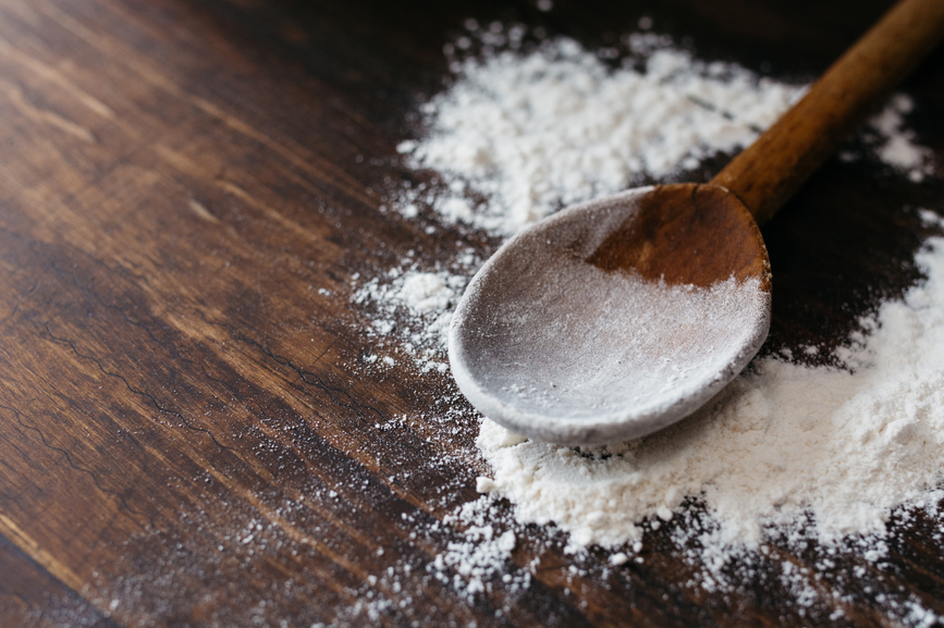 Spoon with flour on the kneading table
